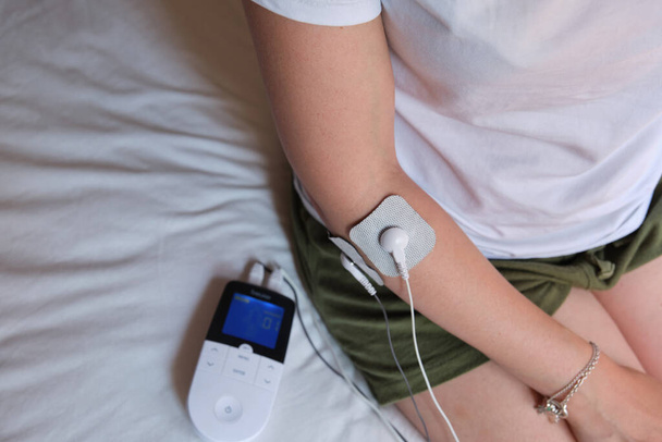 electrostimulation treatment, electrodes on the elbow, tens or ems treatment to reduce inflammation and improve blood circulation. rehabilitation. epicondylitis - Photo, Image