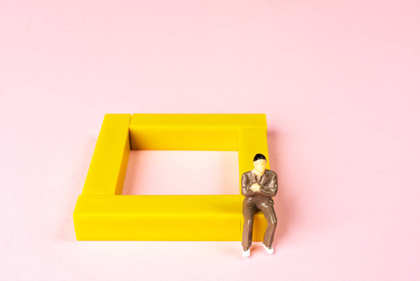 a man sitting at the edge of a colored square - Foto, Imagen