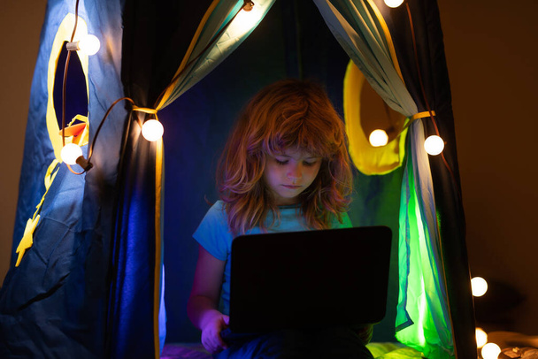 Child boy watching cartoons in bedroom at night. Little hacker, young programmer. - Photo, Image