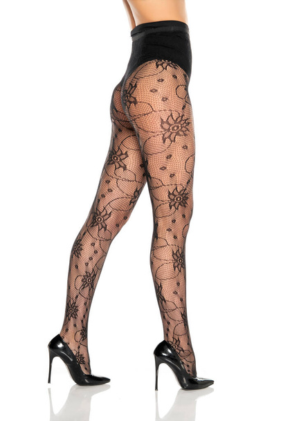 pretty female legs in fishnet stockings and high heels on white background - Foto, Imagem