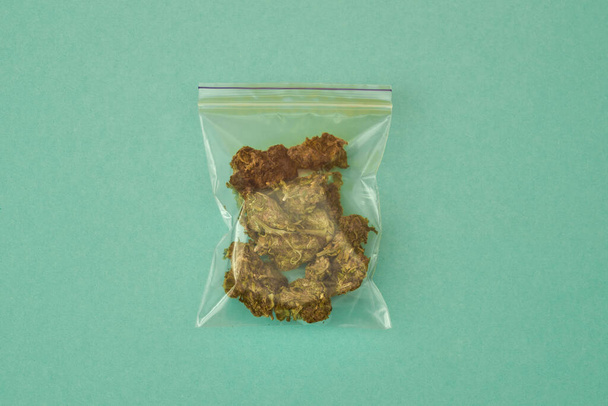Top view of nylon package with dry marijuana - Foto, afbeelding