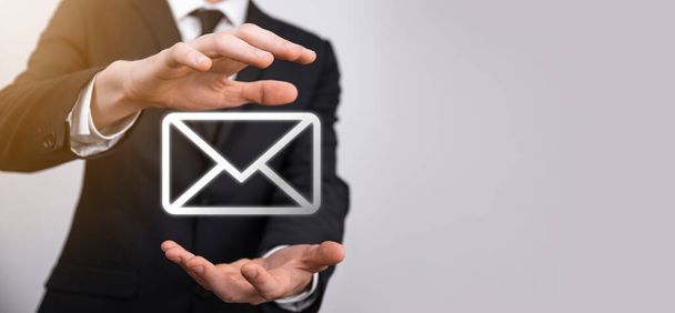 Male hand holding letter icon,email icons .Contact us by newsletter email and protect your personal information from spam mail. Customer service call center contact us.Email marketing and newsletter. - Photo, Image