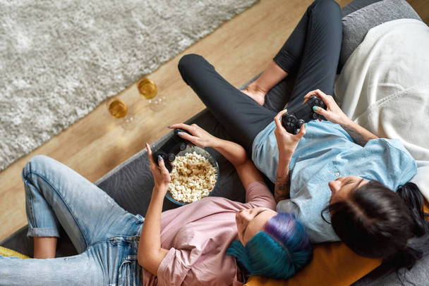 Togetherness concept. Lovely lesbian couple of gamers - 写真・画像
