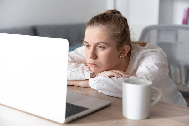 Depressieve studente vermoeid en verveeld voor laptop tijdens virtuele les. Angst en depressie in college concept. - Foto, afbeelding