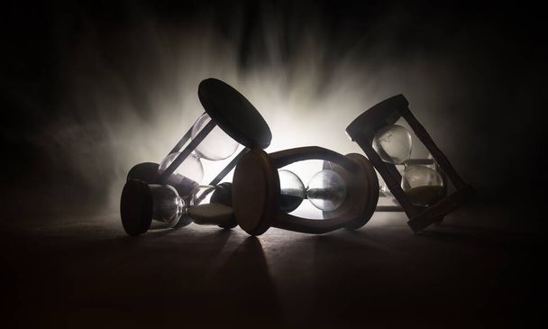 Időkoncepció. Silhouette of Homokóra sötét tónusú háttérrel. Absztrakt koncepció másolási hellyel. Szelektív fókusz - Fotó, kép