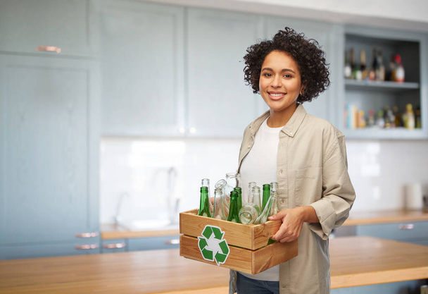 happy woman with bottles sorting glass waste - Foto, imagen