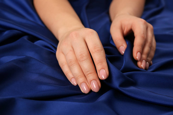 Woman touching silky blue fabric, closeup view - Φωτογραφία, εικόνα