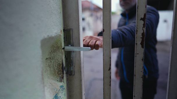 Brazylijczyk zamykający frontowe drzwi wychodzący na ulicę zamyka wejście dla bezpieczeństwa. - Zdjęcie, obraz