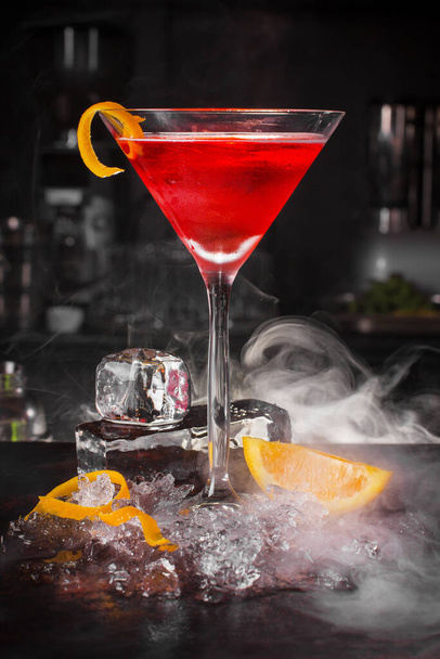 Cocktail drink with fruits and ice cubes on black background - 写真・画像