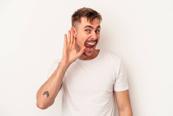 Young caucasian man isolated on white background receiving a pleasant surprise, excited and raising hands. - Fotó, kép