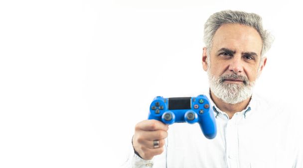 чоловік середнього віку тримає контролер ігрового столу ізольовано на білому тлі
 - Фото, зображення