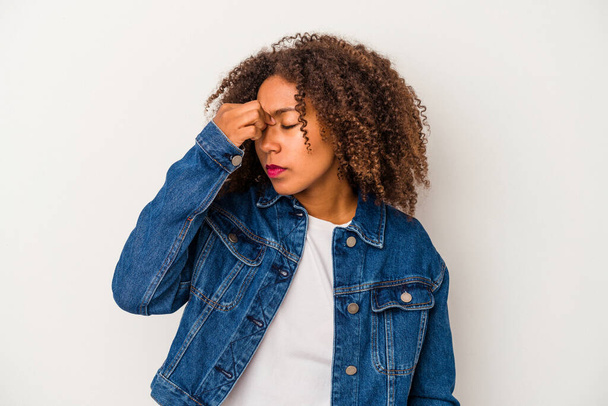 Jonge Afro-Amerikaanse vrouw met krullend haar geïsoleerd op witte achtergrond met een hoofdpijn, aanraken van de voorkant van het gezicht. - Foto, afbeelding