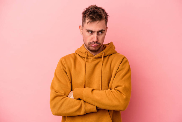 Young caucasian man isolated on pink background tired of a repetitive task. - Photo, Image