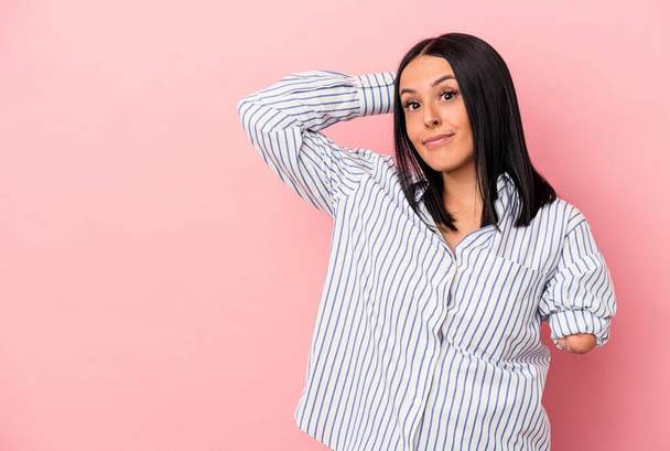 Young caucasian woman with one arm isolated on pink background touching back of head, thinking and making a choice. - Photo, Image
