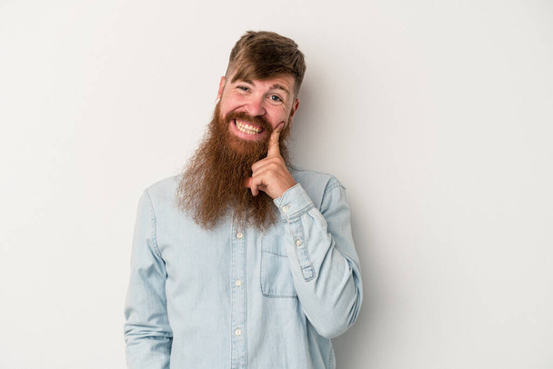 Young caucasian ginger man with long beard isolated on white background smiling happy and confident, touching chin with hand. - Photo, Image