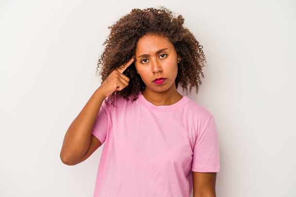 Young african american woman with curly hair isolated on white background pointing temple with finger, thinking, focused on a task. - Foto, immagini