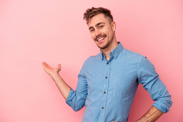 Young caucasian man isolated on pink background showing a welcome expression. - Photo, image