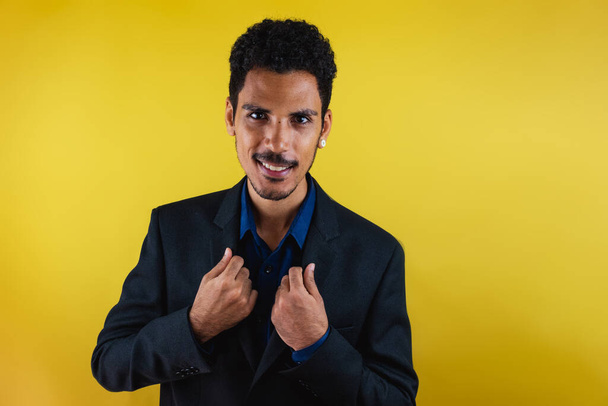 Black man in a suit in the studio isolated on yellow background. - Photo, Image