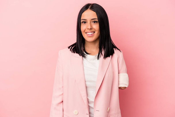 Young caucasian woman with one arm isolated on pink background happy, smiling and cheerful. - Photo, Image