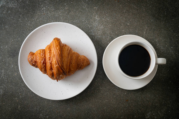 fresh croissant on white plate with black coffee - Fotografie, Obrázek