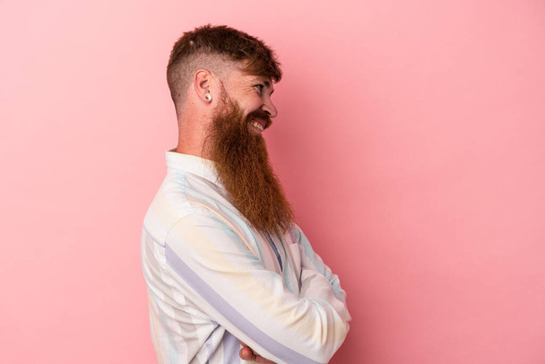 Young caucasian ginger man with long beard isolated on pink background laughing and having fun. - Photo, Image