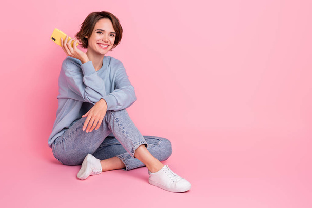 Full length portrait of adorable nice lady sit floor toothy smile look camera isolated on pink color background - Foto, Imagem