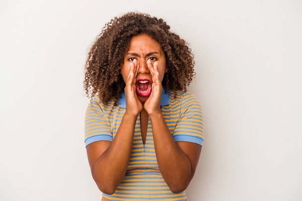 Νεαρή αφροαμερικανή γυναίκα με σγουρά μαλλιά απομονωμένη σε λευκό φόντο φωνάζοντας ενθουσιασμένοι για το μέτωπο. - Φωτογραφία, εικόνα