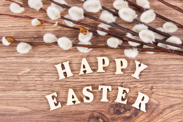 Inscription Happy Easter and catkins on rustic board, festive decoration concept - Fotó, kép