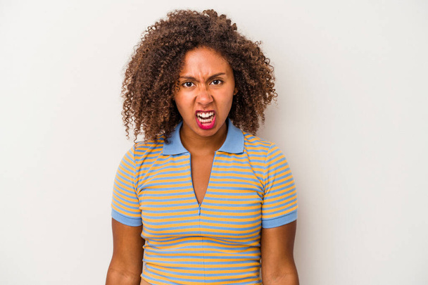 Jeune femme afro-américaine aux cheveux bouclés isolé sur fond blanc criant très en colère, concept de rage, frustré. - Photo, image