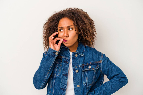 Νεαρή Αφροαμερικανή γυναίκα με σγουρά μαλλιά απομονωμένη σε λευκό φόντο με δάχτυλα στα χείλη κρατώντας ένα μυστικό. - Φωτογραφία, εικόνα