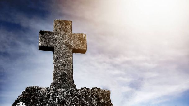 Náboženské pozadí - Modrá oblačná obloha s ošlehaným kamenným křížem, ozářená sluncem - Fotografie, Obrázek
