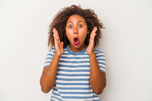 Junge afrikanisch-amerikanische Frau mit lockigem Haar isoliert auf weißem Hintergrund überrascht und schockiert. - Foto, Bild