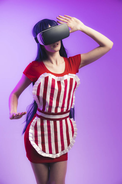 Happy young caucasian woman using a virtual reality headset medium studio shot magenta background  - Photo, Image