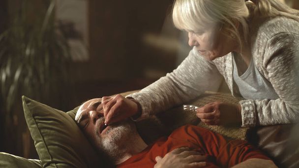 Aged wife taking care of ill husband - Foto, immagini