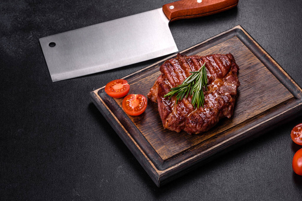 Medium rare sliced grilled striploin beef steak served on wooden board - Fotó, kép