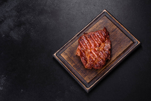 Közepes, ritka szeletelt grillezett csíkos marhahús fapadlón tálalva - Fotó, kép