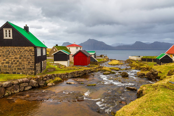 Μικρό χωριό Gjogv βρίσκεται στην πλαγιά του βουνού στο νησί Streymoy. Νήσοι Φερόε, Δανία. - Φωτογραφία, εικόνα