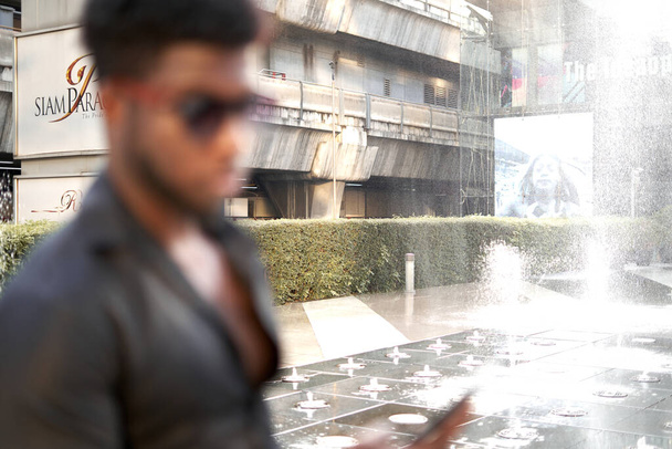 Focus on a building of a mall with an african stylish man - Photo, Image