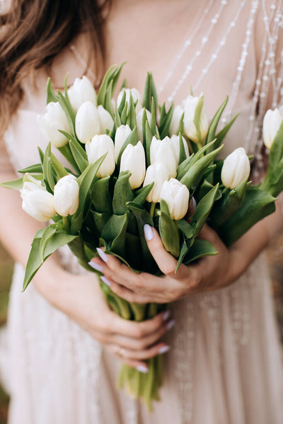 Big beautiful bouquet of white tulips in the hands of the bride - Fotoğraf, Görsel