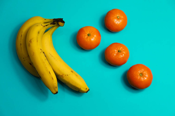 青い背景の果物、バナナ、みかん - 写真・画像