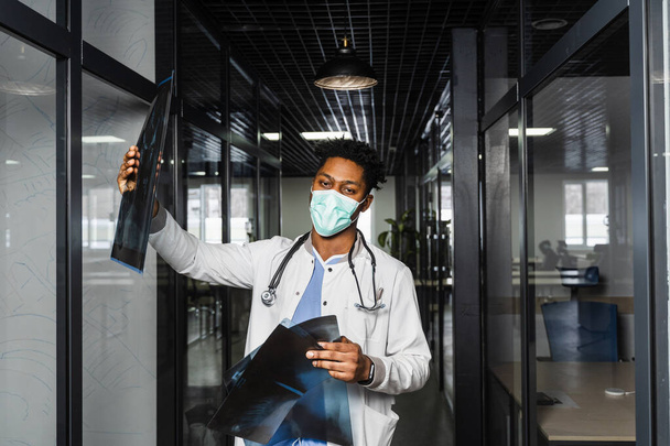 Αφρικανός γιατρός με ακτινογραφία στην ιατρική κλινική. Μαύρος φοιτητής ιατρικής στην ιατρική μελέτη μάσκα στο πανεπιστήμιο - Φωτογραφία, εικόνα