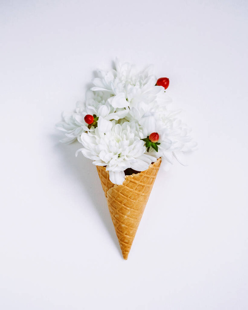 Szép egyedi virág fagylalt kúp fehér háttér. Virágkötészet, lapos fektetés. Első látásra. Kreatív csendélet ötlet tavaszi tapéta. Festői és gyönyörű jelenet. Szépségvilág. - Fotó, kép