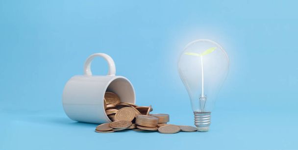 saving concept. idea of light bulb and coins on blue background. - Valokuva, kuva