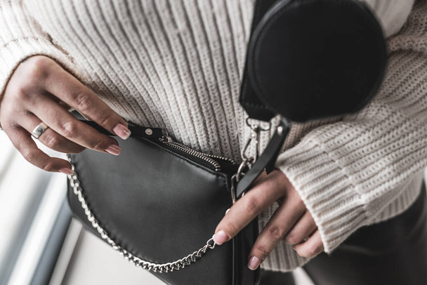 młoda elegancka stylowa kobieta trzyma fajną czarną skórzaną torbę. Koncepcja stylu. Koncepcja wyrafinowania - Zdjęcie, obraz