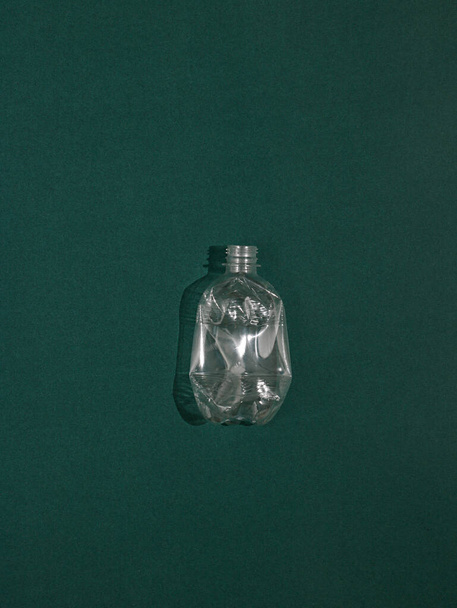 empty glass bottle on a green background - Foto, imagen
