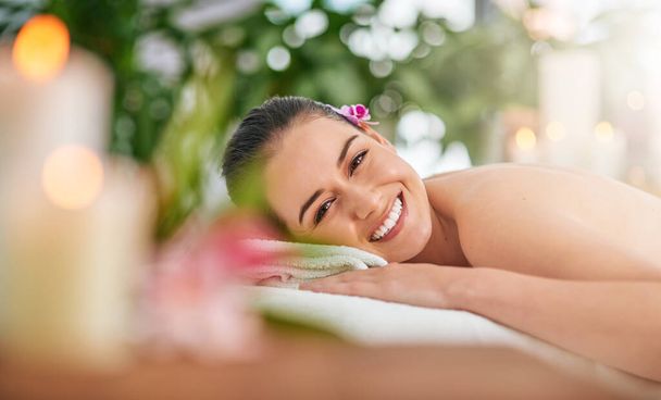 Paradise is here right at the spa. Portrait of an attractive young woman relaxing on a massage table at a spa. - Foto, Bild