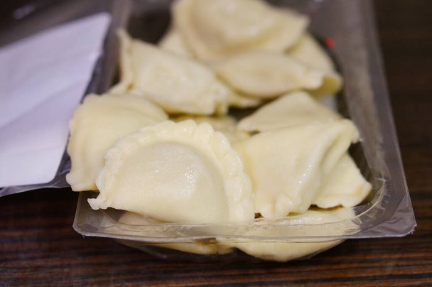 raw dumplings on a wooden board - Фото, зображення