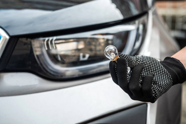 mechanic changing light bulb in his car. technology - Φωτογραφία, εικόνα