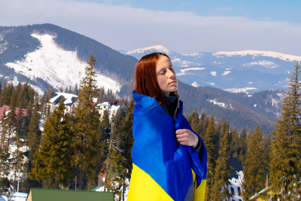 Vrouw die, het dragen van Oekraïense nationale blauwe gele vlag.Oorlog, conflict, militaire invasie kevers Rusland als terroristische agressieve wrede land en Oekraïne.Oekraïense Onafhankelijkheid vlag, Constitutionele dag. - Foto, afbeelding