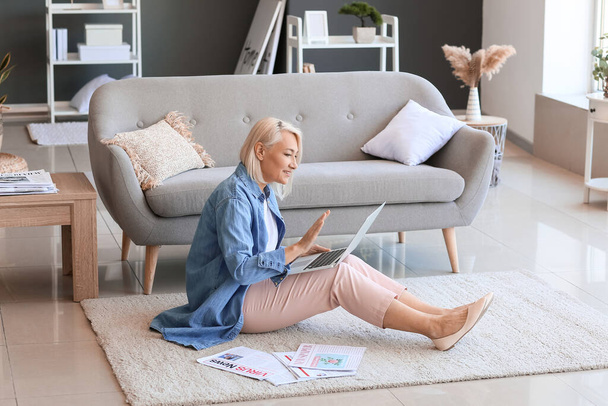 Gyönyörű érett nő használja laptop padlón otthon - Fotó, kép